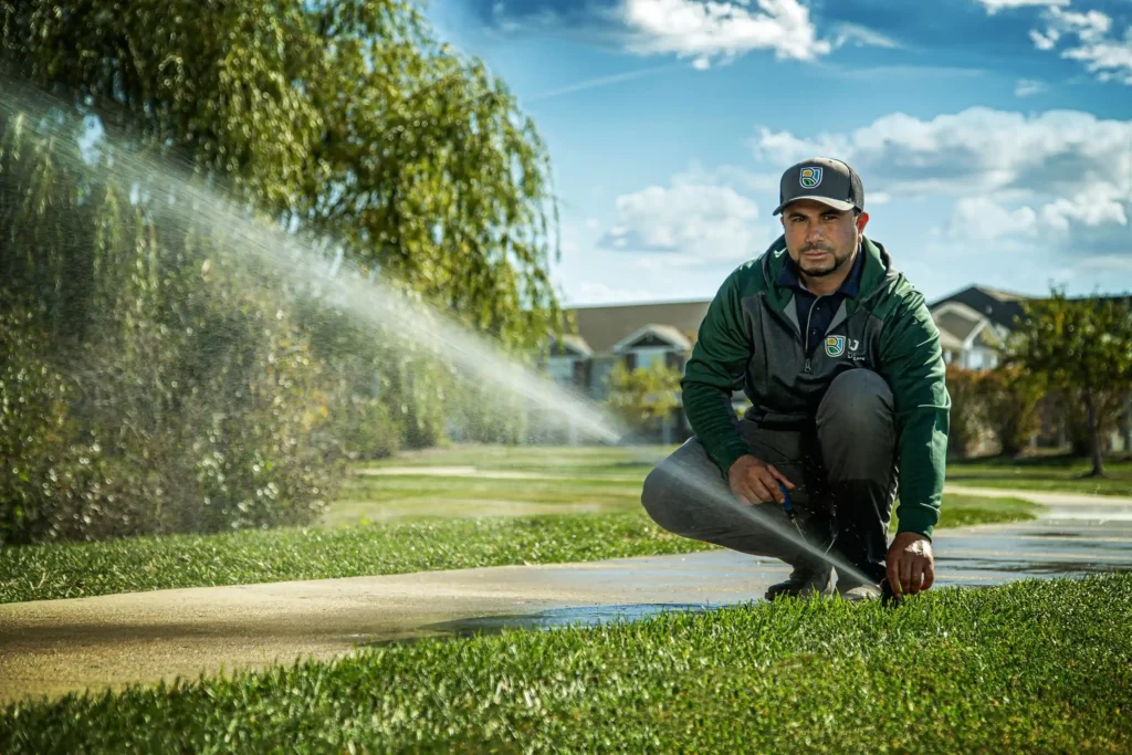 man adjusting sprinkler head